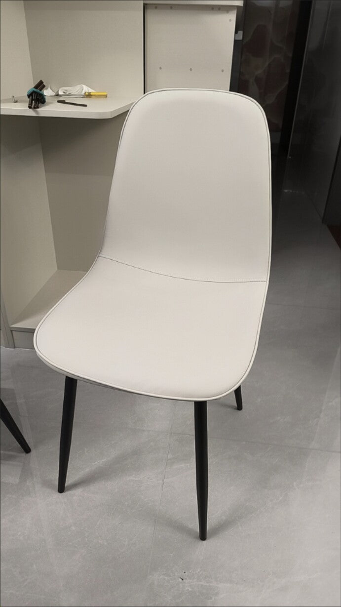 Chaise de salle à manger contemporaine en acier au carbone avec revêtement en similicuir incurvé pour salon 