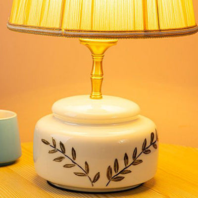 Lampe de table à 1 lumière avec abat-jour en tissu plissé trapézoïdal contemporain et base en céramique ronde pour chambre 