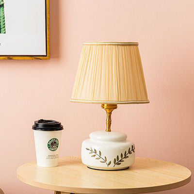 Lampe de table à 1 lumière avec abat-jour en tissu plissé trapézoïdal contemporain et base en céramique ronde pour chambre 