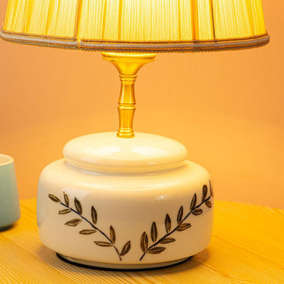 Lampe de table à 1 lumière avec abat-jour en tissu plissé trapézoïdal contemporain et base en céramique ronde pour chambre 