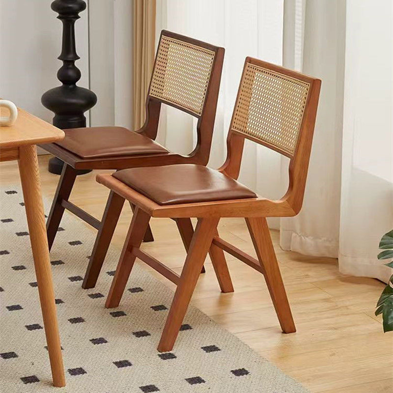 Moderna silla de comedor sin brazos de goma en forma de H nórdica contemporánea con respaldo de ratán tejido y esponja de cuero PU para el comedor 