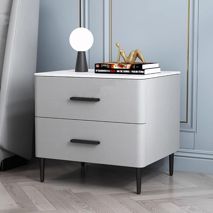 Table de chevet contemporaine scandinave en pierre frittée, bois massif, cuir microfibre et fer, de forme carrée arrondie cylindrique, avec 2 tiroirs pour la chambre 